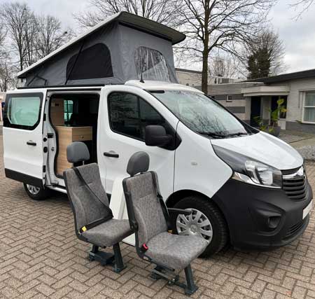 Camper met losse stoelen voor op vloerrails